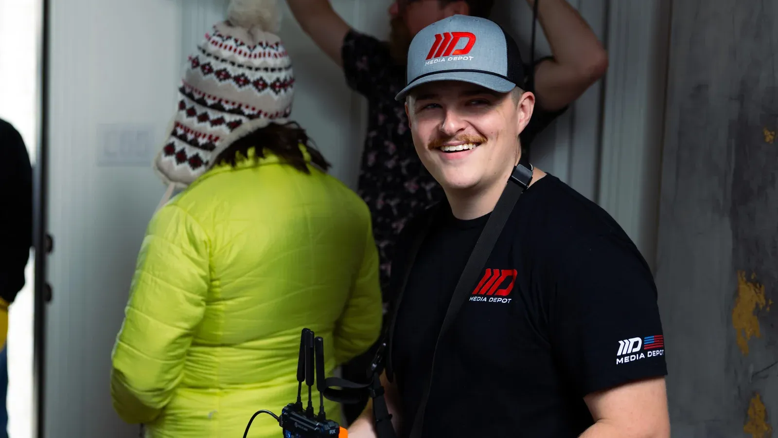 A Media Depot crew member in a branded cap on location between setups