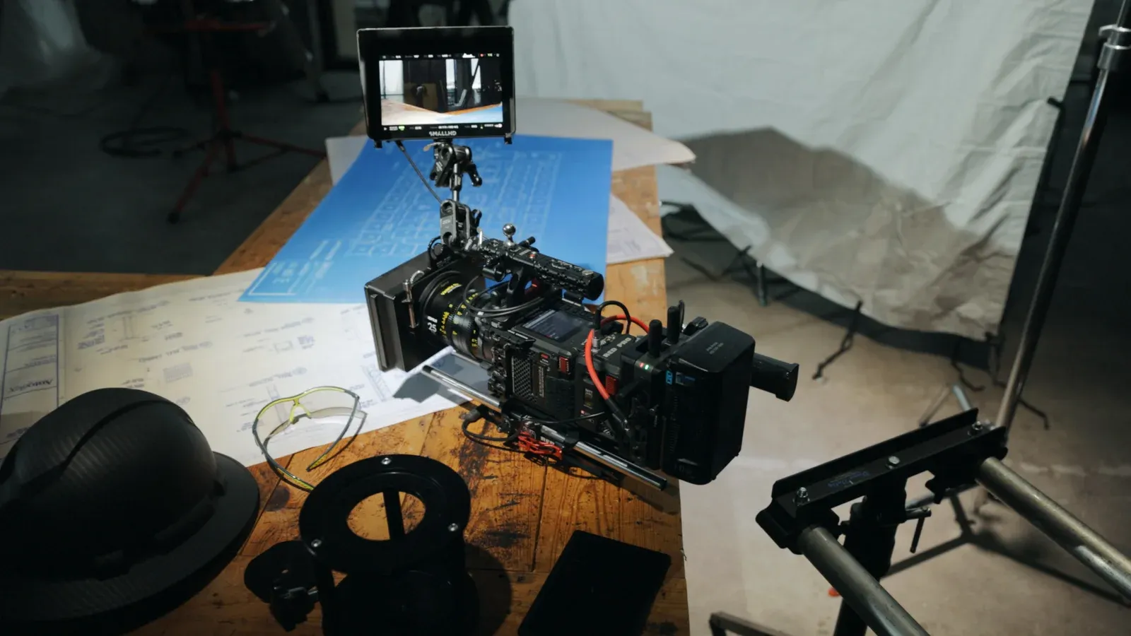A cinema camera built up on the table beside the shot list