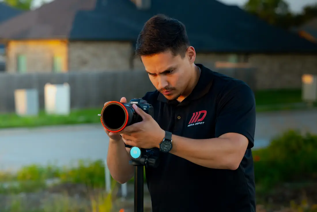 A Media Depot photographer setting up outside a listing at golden hour